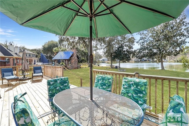 wooden terrace featuring a water view and a lawn