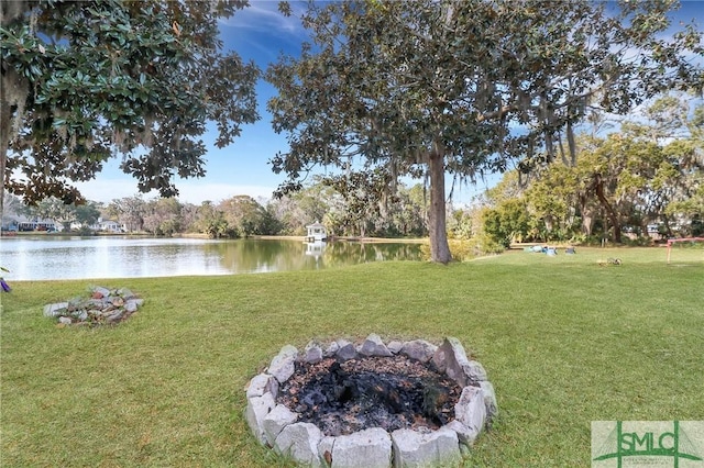 view of yard featuring a water view and an outdoor fire pit