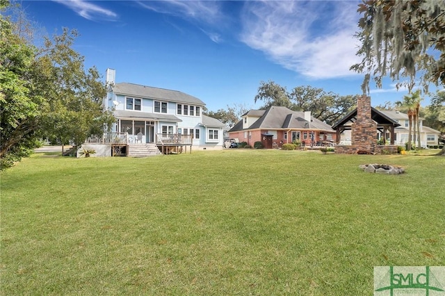 back of house featuring a lawn and a sunroom