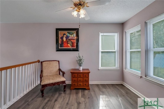 sitting room with ceiling fan, plenty of natural light, a textured ceiling, and hardwood / wood-style floors