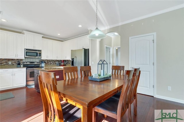 dining space featuring arched walkways, recessed lighting, dark wood-style flooring, baseboards, and crown molding