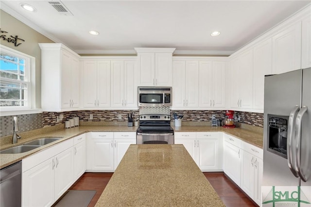 kitchen with dark wood-style floors, visible vents, appliances with stainless steel finishes, white cabinets, and a sink