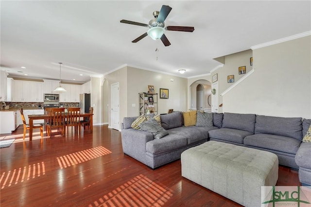 living room featuring sink, dark wood-type flooring, ornamental molding, and ceiling fan