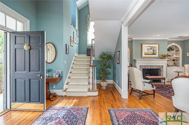 foyer entrance featuring a fireplace, a wealth of natural light, and light wood-type flooring