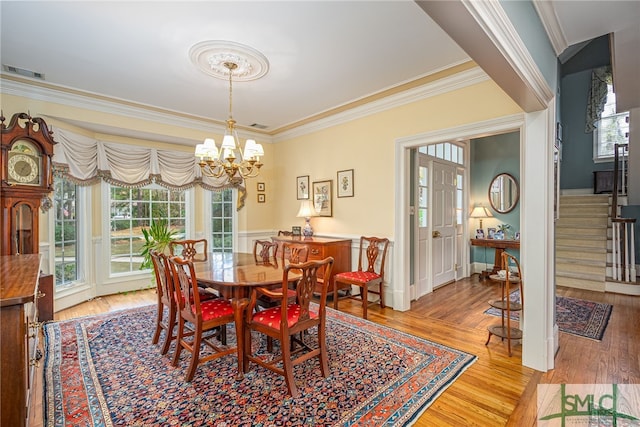 dining room featuring crown molding, a chandelier, and light hardwood / wood-style floors