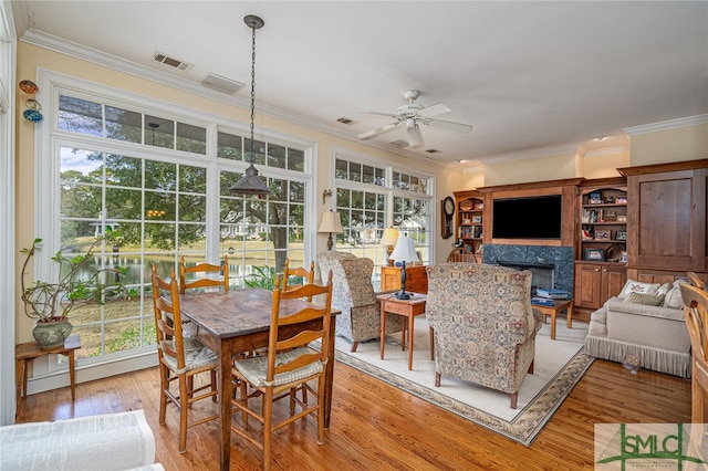 dining room with ceiling fan, a high end fireplace, and a wealth of natural light