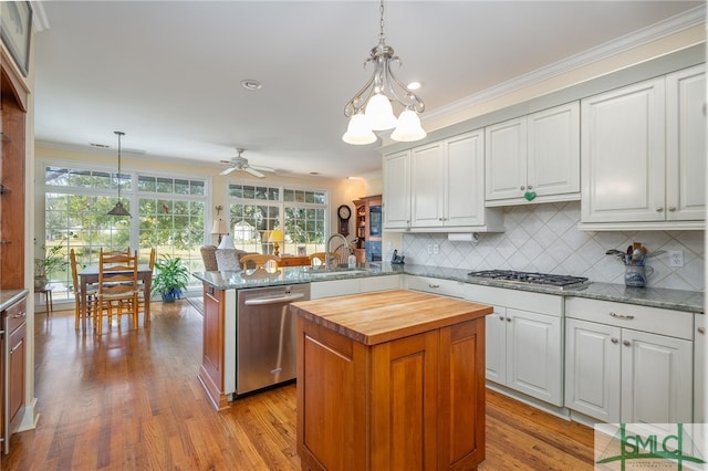 kitchen with white cabinetry, hanging light fixtures, kitchen peninsula, and stainless steel appliances