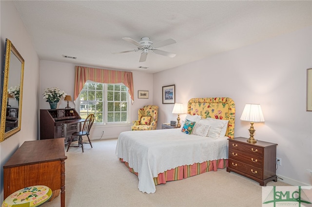 carpeted bedroom with ceiling fan and a textured ceiling