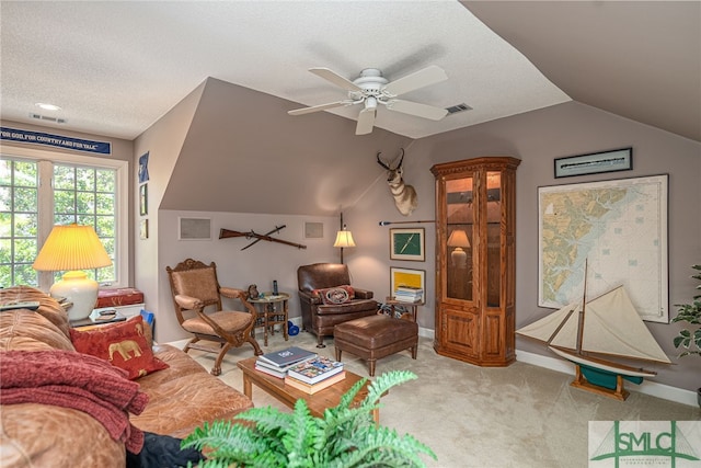 living room with ceiling fan, light colored carpet, vaulted ceiling, and a textured ceiling