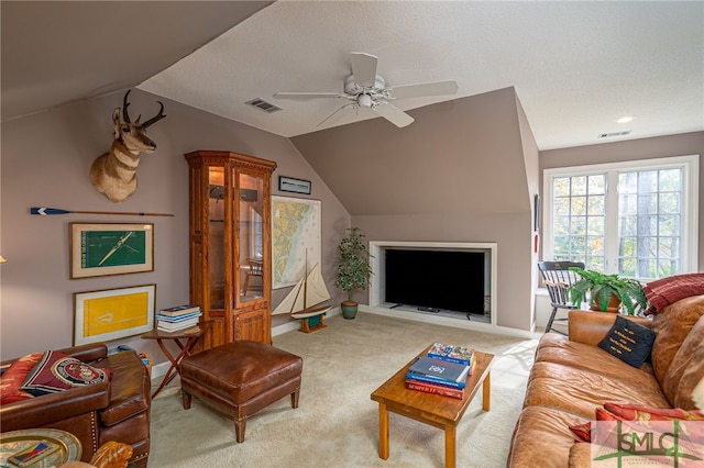 carpeted living room with ceiling fan and vaulted ceiling