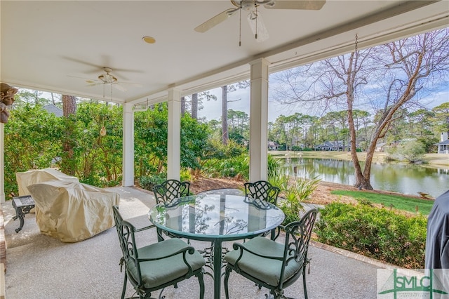 sunroom featuring ceiling fan, plenty of natural light, and a water view