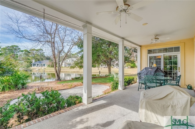 sunroom featuring a water view and ceiling fan