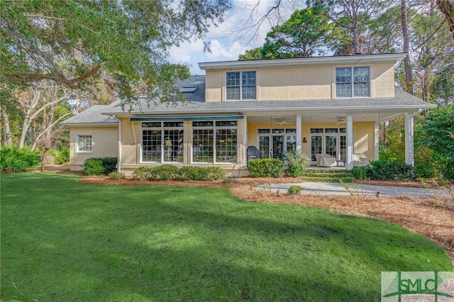 rear view of house with ceiling fan, french doors, and a yard