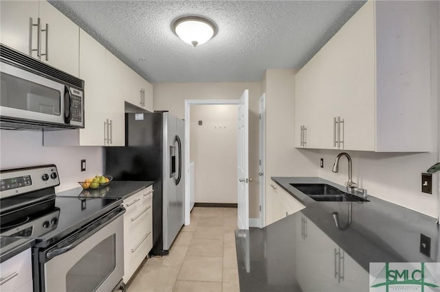 kitchen featuring white cabinets, sink, stainless steel appliances, and a textured ceiling