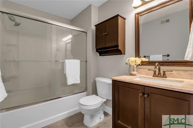 full bathroom featuring bath / shower combo with glass door, toilet, vanity, and tile patterned flooring