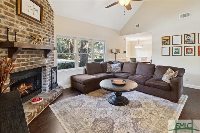 living room with ceiling fan, dark hardwood / wood-style flooring, a fireplace, and high vaulted ceiling