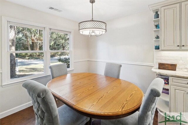 dining room with plenty of natural light and dark hardwood / wood-style flooring