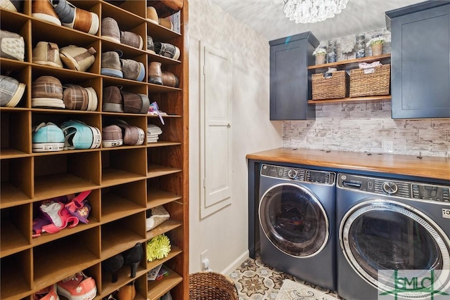 laundry area featuring cabinets, independent washer and dryer, and a notable chandelier