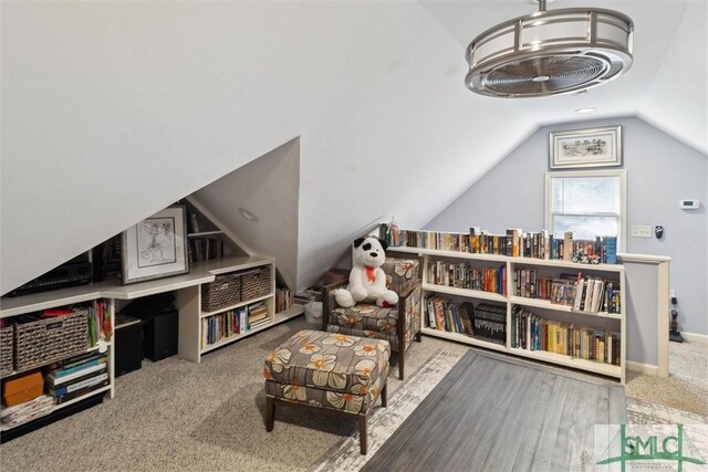 living area featuring vaulted ceiling and carpet flooring