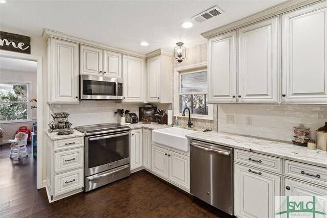 kitchen featuring dark wood-type flooring, appliances with stainless steel finishes, tasteful backsplash, and sink