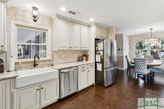 kitchen with pendant lighting, dark hardwood / wood-style flooring, stainless steel appliances, decorative backsplash, and sink