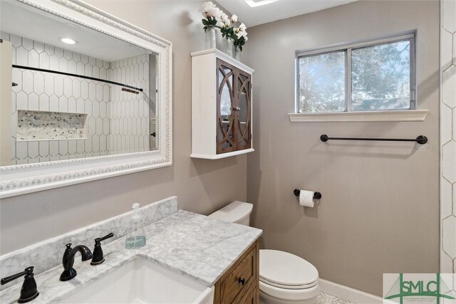 bathroom featuring toilet, vanity, and walk in shower