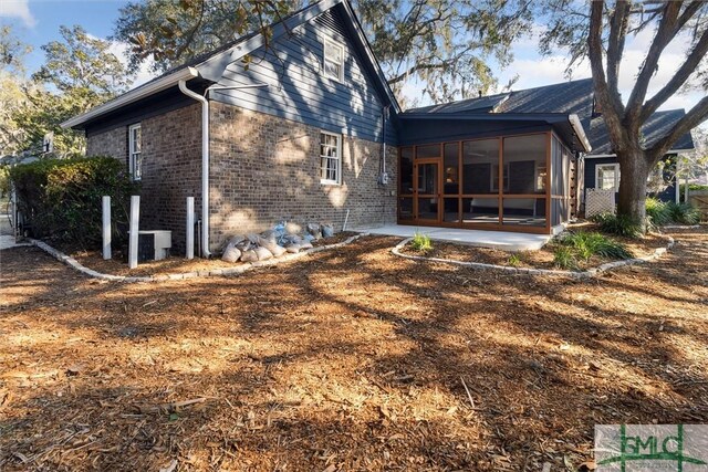 rear view of house featuring a patio and a sunroom