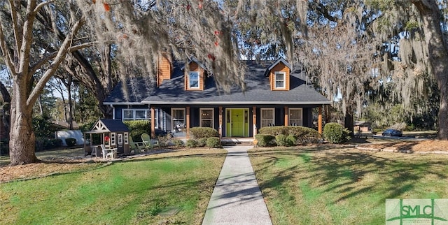 cape cod home featuring a front yard