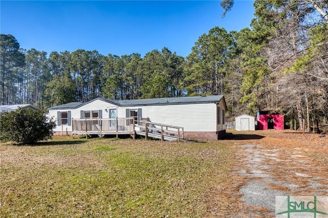 back of house featuring a lawn, a storage unit, and a deck