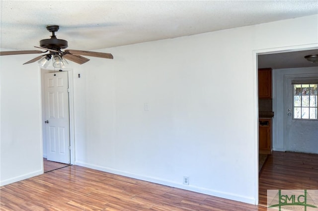 empty room with hardwood / wood-style flooring, a textured ceiling, and ceiling fan