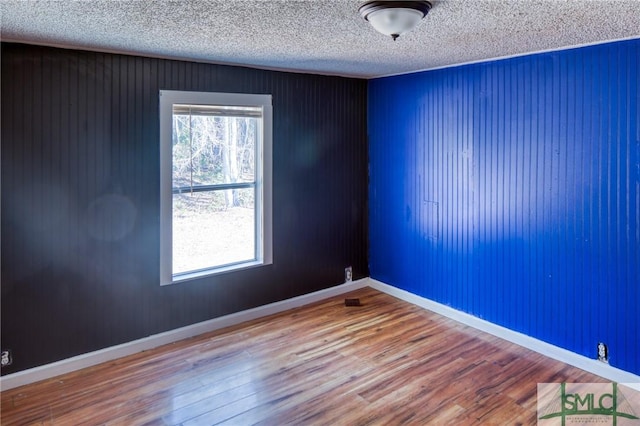 unfurnished room with a textured ceiling and hardwood / wood-style flooring