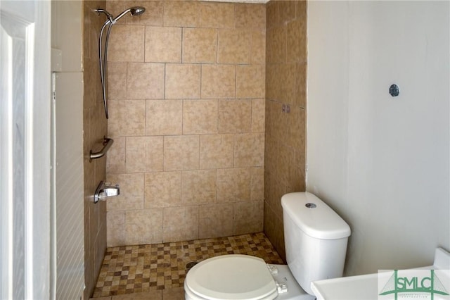 bathroom with toilet and a tile shower