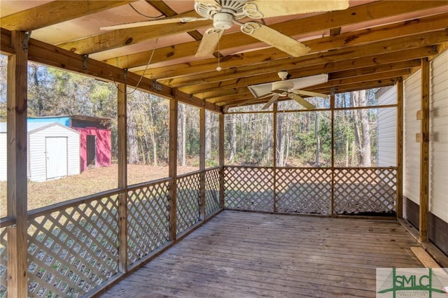 unfurnished sunroom with ceiling fan and lofted ceiling with beams