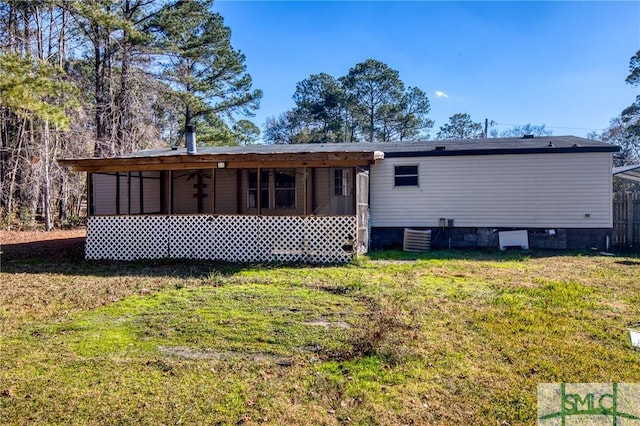 rear view of house with a yard and a sunroom