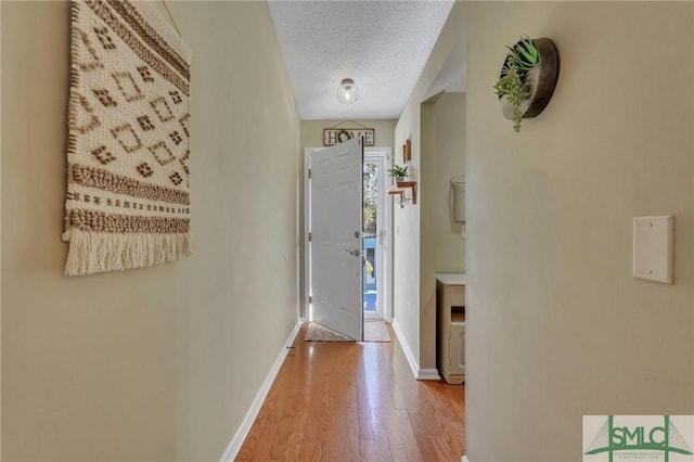 interior space with a textured ceiling and hardwood / wood-style floors