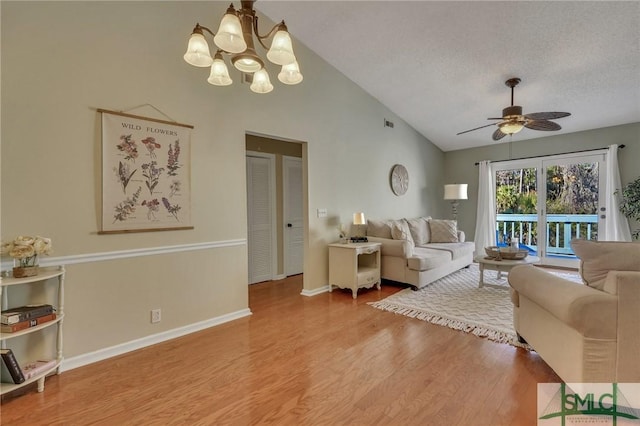 living room featuring a textured ceiling, lofted ceiling, ceiling fan with notable chandelier, and hardwood / wood-style floors