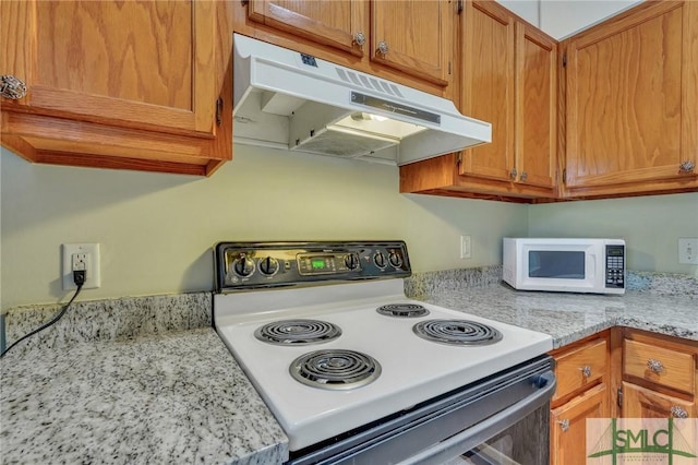 kitchen with light stone countertops and white appliances