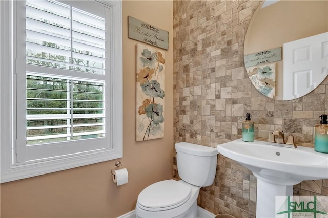 bathroom featuring toilet and tasteful backsplash