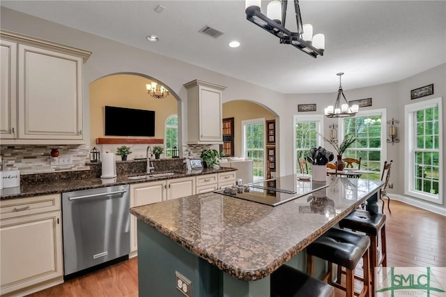 kitchen featuring a chandelier, dishwasher, a kitchen island, and sink