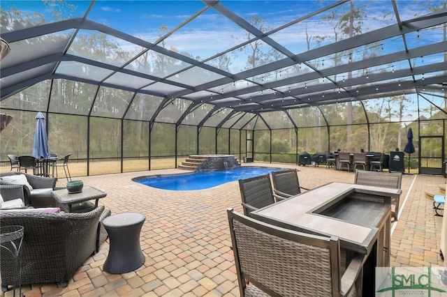 view of patio / terrace featuring a swimming pool with hot tub, a lanai, and pool water feature