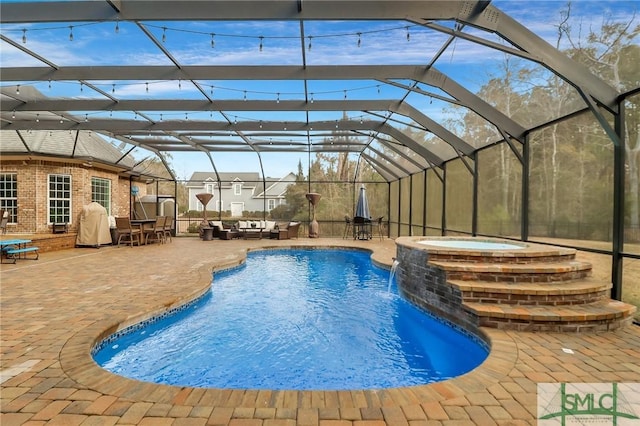 view of swimming pool featuring pool water feature, a patio, glass enclosure, and an in ground hot tub