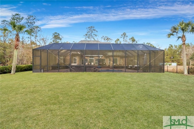 back of property with glass enclosure and a yard