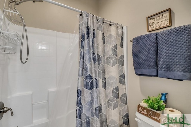 bathroom featuring toilet and a shower with shower curtain