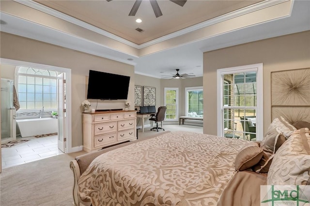 carpeted bedroom with ceiling fan, a tray ceiling, crown molding, and multiple windows