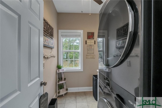 laundry room with ceiling fan, stacked washer / dryer, and light tile patterned floors