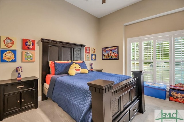 bedroom featuring ceiling fan, light colored carpet, and multiple windows