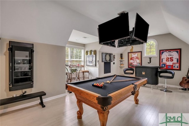 recreation room featuring vaulted ceiling, light hardwood / wood-style flooring, bar area, and billiards