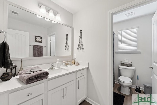 bathroom with hardwood / wood-style floors, toilet, and vanity