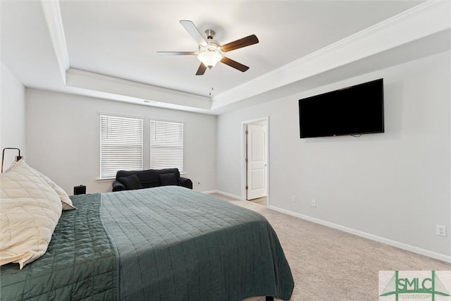 carpeted bedroom with a raised ceiling, ceiling fan, and ornamental molding