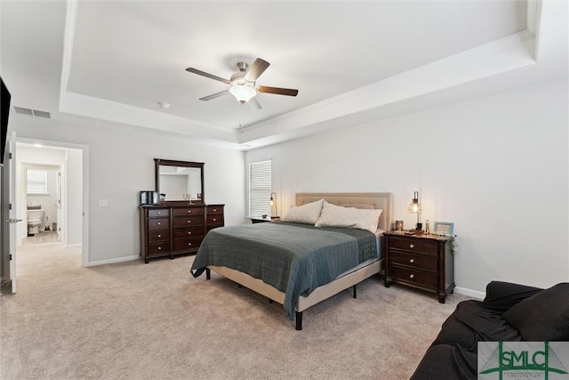 carpeted bedroom with ceiling fan, a tray ceiling, and multiple windows